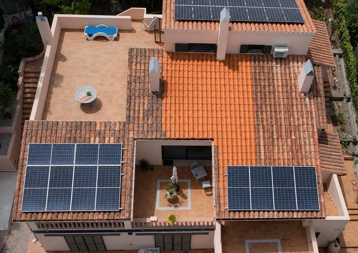 Luftaufnahme einer Mallorca-Villa: Dachterrassen und Ziegel während der Reinigung, der gereinigte Bereich leuchtet hell